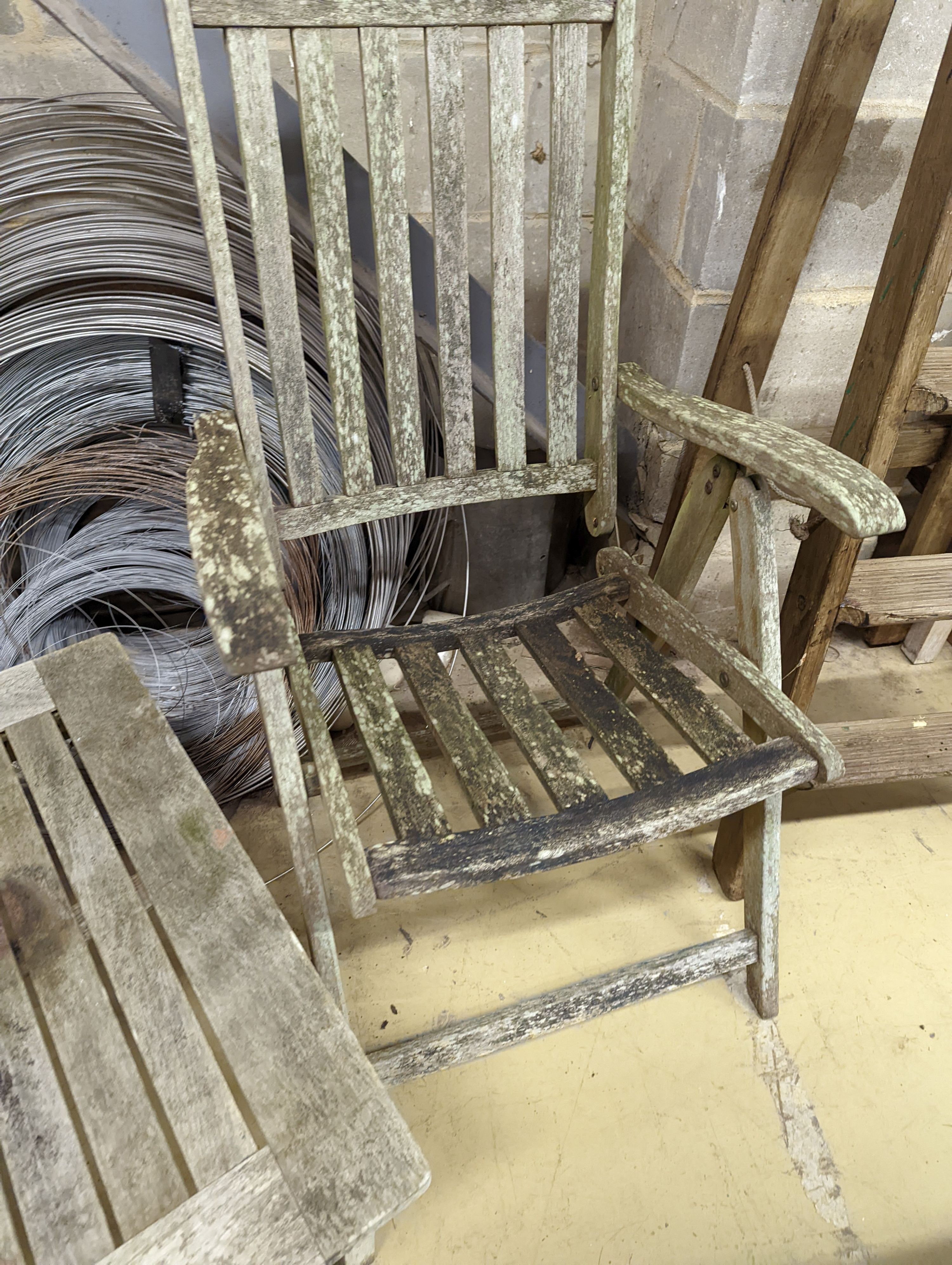 Two weathered teak folding garden armchairs and a low table
